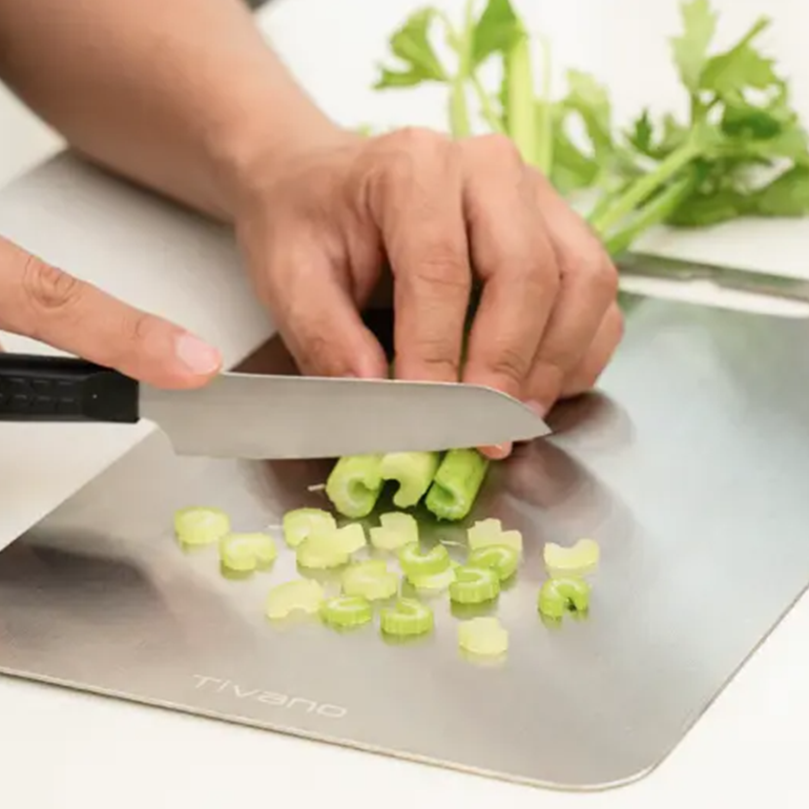 Celery being sliced on the Tivano cutting board